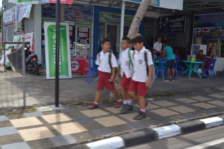 マナドの街に出ると、 学生が帰路しているところに遭遇。 学校がおわった開放感にあふれ、 いい顔をしながら道を歩いていたり、 バスを待っている。  それぞれの学校によって、制服が異なっていて、 世界無形文化遺産に認定されたインドネシアの伝統柄 「バティック柄」をモチーフにデザインされているのが、 とても、すてきだ。  車のなかにも、学生がいるんだけど、見られるかな？   それでは、今日も、明日も、明後日も、いい１日を。 世界遺産が生活に溶けこんでいる。  この時の地点／マナド