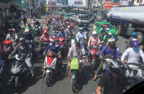 ホーチミンシティーのバイクの量は、 まるで、アリの大群のようだ。 友どちのバイクの後ろに乗せてもらったのだけど、 信号待ちをすると、 １００台近くのバイクが前後に並んでいて、 信号が青に変わる瞬間に、 マラソン大会で一斉にスタートする、 あの感じを味わえる。 しかも、やる気のない思春期まっ最中の 生徒の多い中学、高校のマラソン大会と違って、 みんながやる気のあるランナーなもんで、 クラクションを鳴らし、 我先にと追い抜いていくのだ。 歩道をどうどうと走るバイクや、 進行方向とは逆に走ってくるバイクも結構いる。 交通ルールは、あるようでない。 ここを走るには、図々しさと謙虚さが必要だ。 図々しさがないと、 カットインすることができずに、 いつになっても道路を曲がれない。 謙虚さがないと、止まることができず、 ぶつかってしまう。 ホーチミンシティーの道路には、 図々しさと謙虚さが交差している。 ホーチミンの道路を見て、よくもまあ、 事故らないなあと感心するかもしれないが、 友だちは３回ほど事故を起こしたことがあるそうで、 きっと、いろんな場所で毎日事故が起きている。 そして、プノンペンからホーチミン行きの ぼくが乗っていたバスもバイクに接触して、 停車する車内で１時間半待たされた。 代りのバスが来たと思ったら、 ２ドル５０セント払えて言われ、 あれ、なんで、これぼくが払うのだろうか。 混んでいる場所では、図々しさと謙虚さ。 これは、道路だけじゃないと思う。 狭き門であれば、相手から指名されるんじゃなくて、 自分から手を挙げる必要があるし、 多くの人と人が交わる場所では、 譲ることでコミュニケーションが成立する。 それでは、今日も、明日も、明後日も、いい１日を。 タイミングを間違えると、事故が起きる。 このときの場所／ベトナム ホーチミンシティー 現在地／ にほんブログ村の「旅行ブログ」に参加しています。 よかったら、「見たよ」のあかしに、世界一周バナーをクリックして下さい。 　１日１回のクリックが応援になる仕組みです。 [alert]感想を送る[/alert]